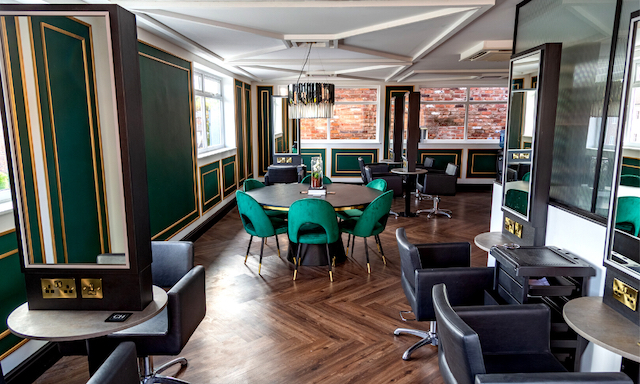 green panelling on cream walls, seats and mirrors on right and a round black table with green chairs
